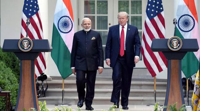 Prime Minister Narendra Modi and US President Donald Trump smiling with India and USA flags in the background