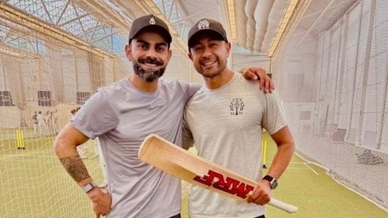 Virat Kohli with GT coach after net practice, smiling with MRF bat in hand
