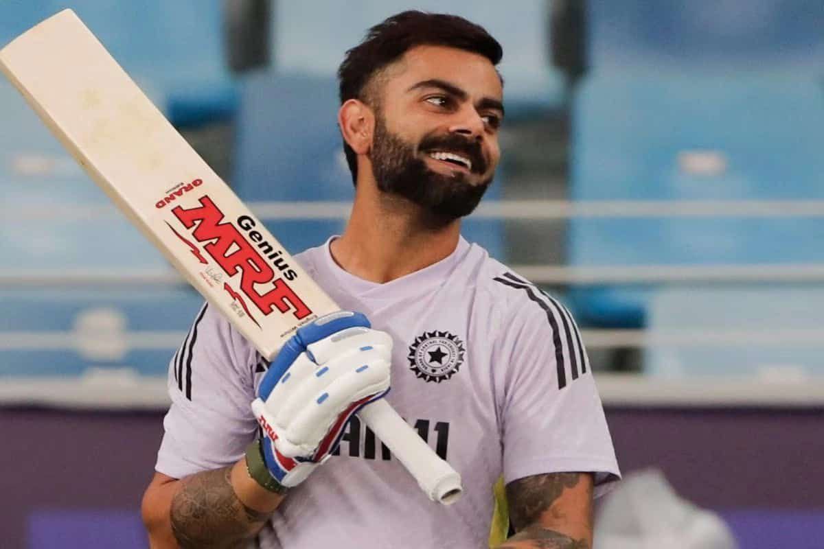 "Virat Kohli हाथ में बैट लिए मुस्कुराते हुए, क्रिकेट तैयारी के दौरान"
